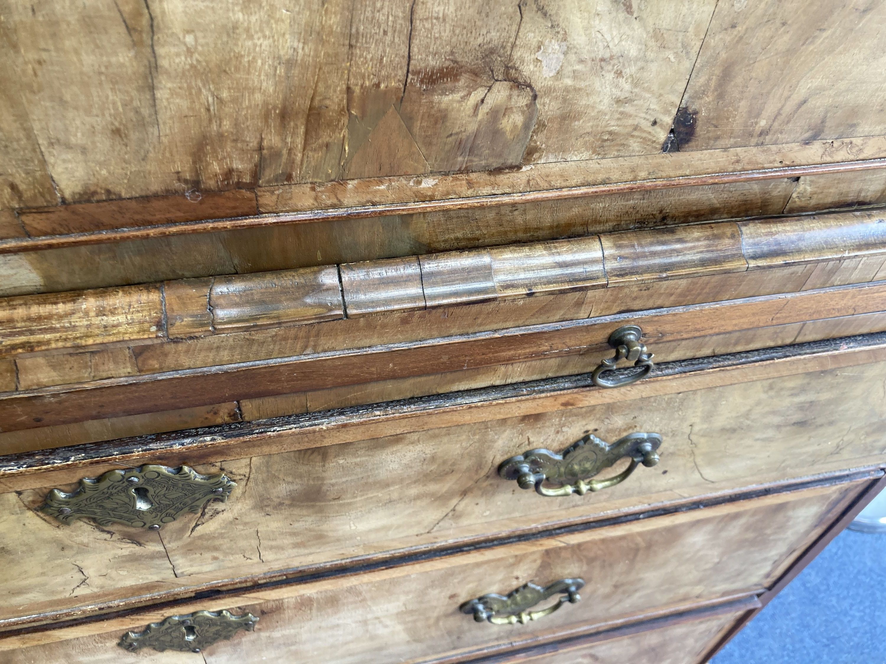 An early 18th century banded walnut tallboy, with oak sides, fitted three small and six long drawers with a brushing slide, width 105cm